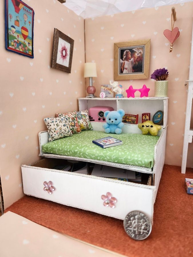 Cozy child’s bedroom with a white daybed, green bedding, stuffed animals, and pink star lights