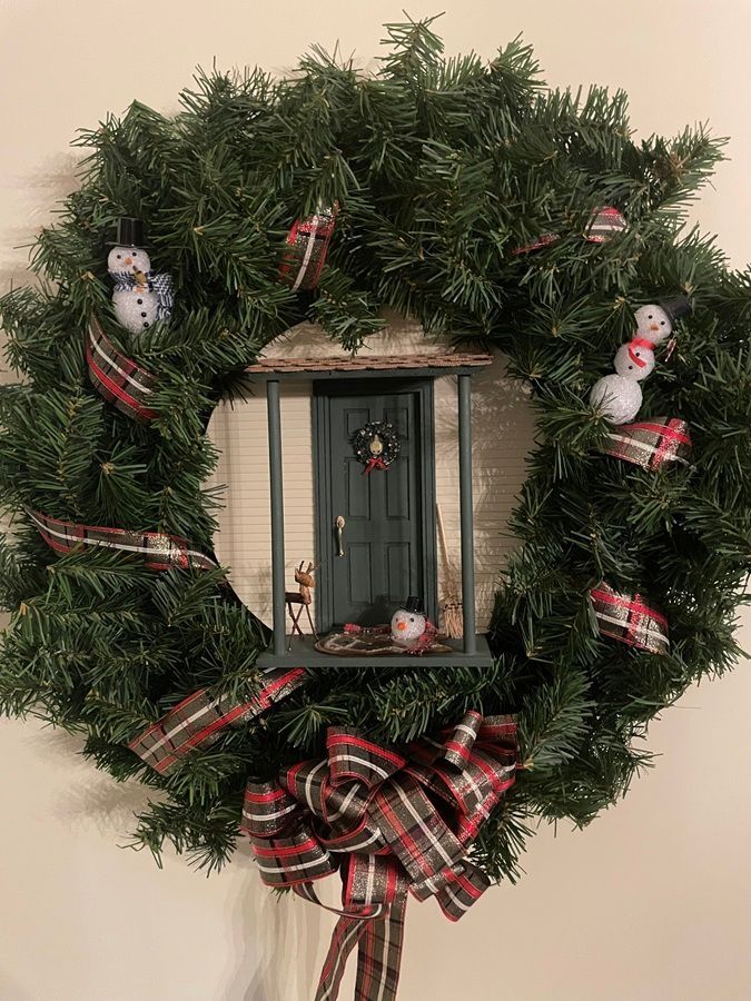 Christmas wreath with plaid bow, miniature doorway, and small snowman decorations