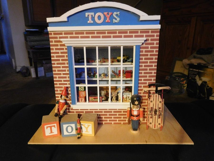 Toy store display with brick facade, blue window, toy blocks, nutcracker, and wooden fence