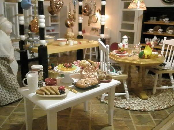 Tea party setup with pastries and cups on white tables in a cozy living room