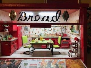 Bread shop interior with red decor, green chairs, tables, and bread-themed signage