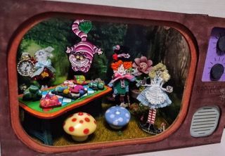 Whimsical dollhouse scene with colorful characters and mushroom stools inside a retro TV frame