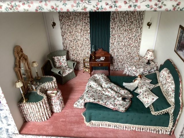 Miniature living room diorama with floral wallpaper, green sofa, armchairs, and a small table