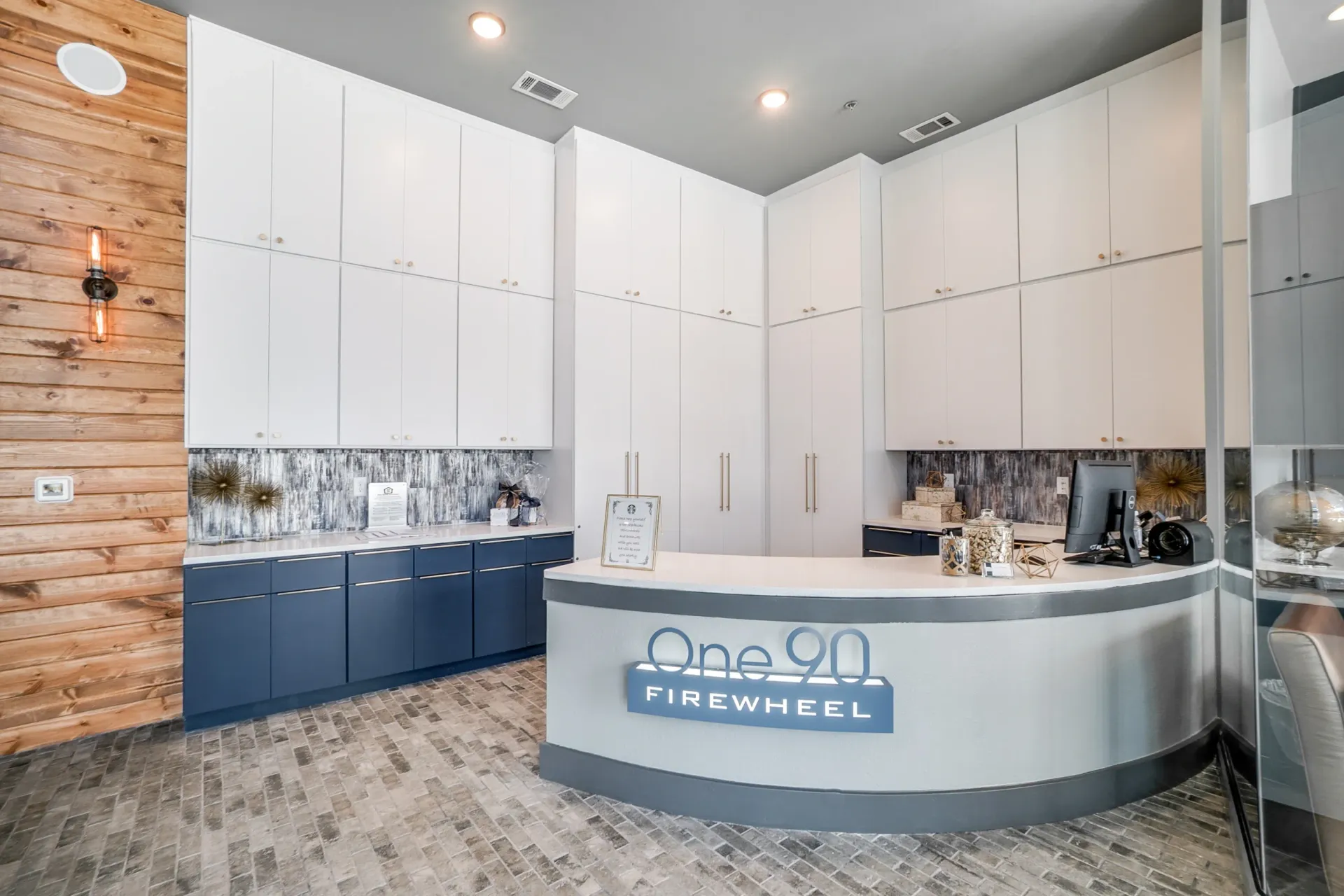 Leasing office reception with white upper cabinets, blue lower cabinets, and a curved front desk.