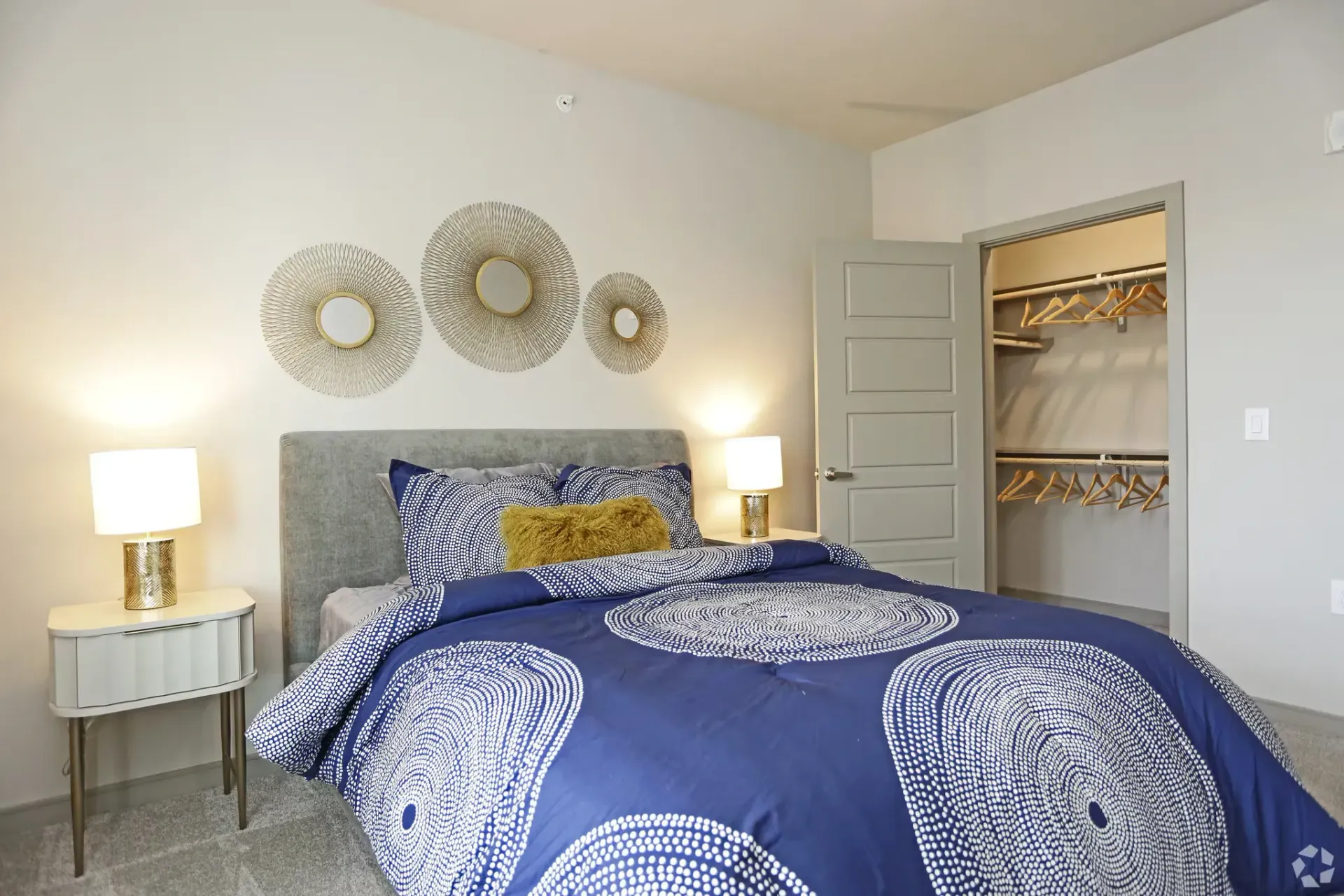 Bedroom in an apartment with a bed, nightstands, and an open closet.