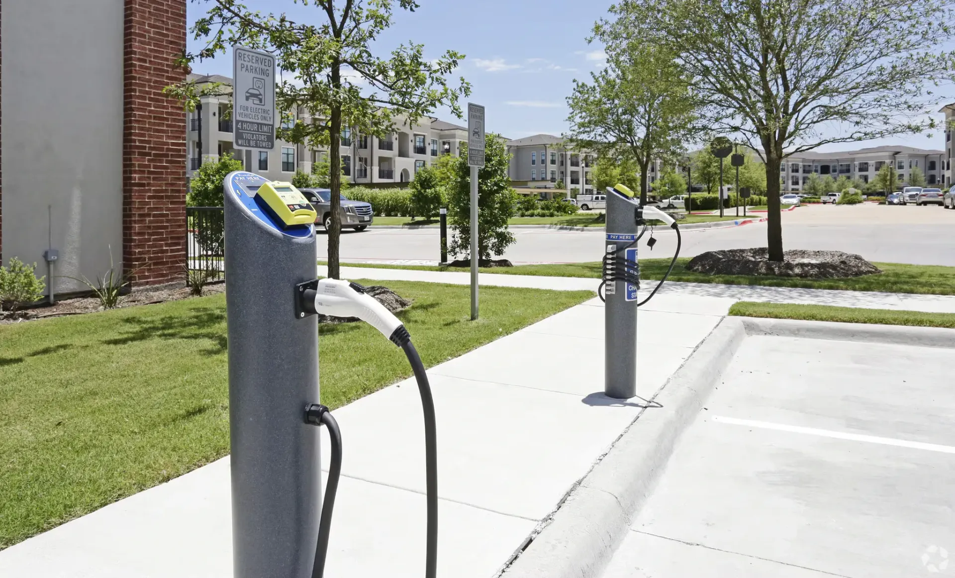 EV charging stations in a landscaped parking area at a residential apartment complex.