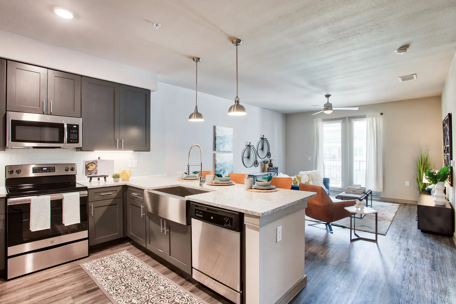 Open-concept kitchen and living area in a modern apartment with stainless steel appliances.