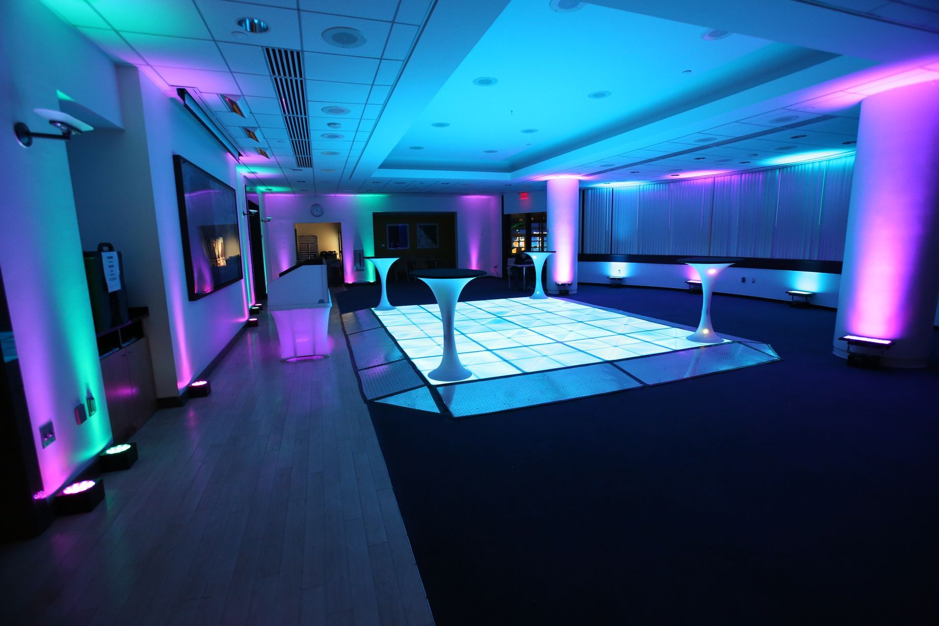 There is a led lit dance floor in the middle of the room with perimeter up-lighting