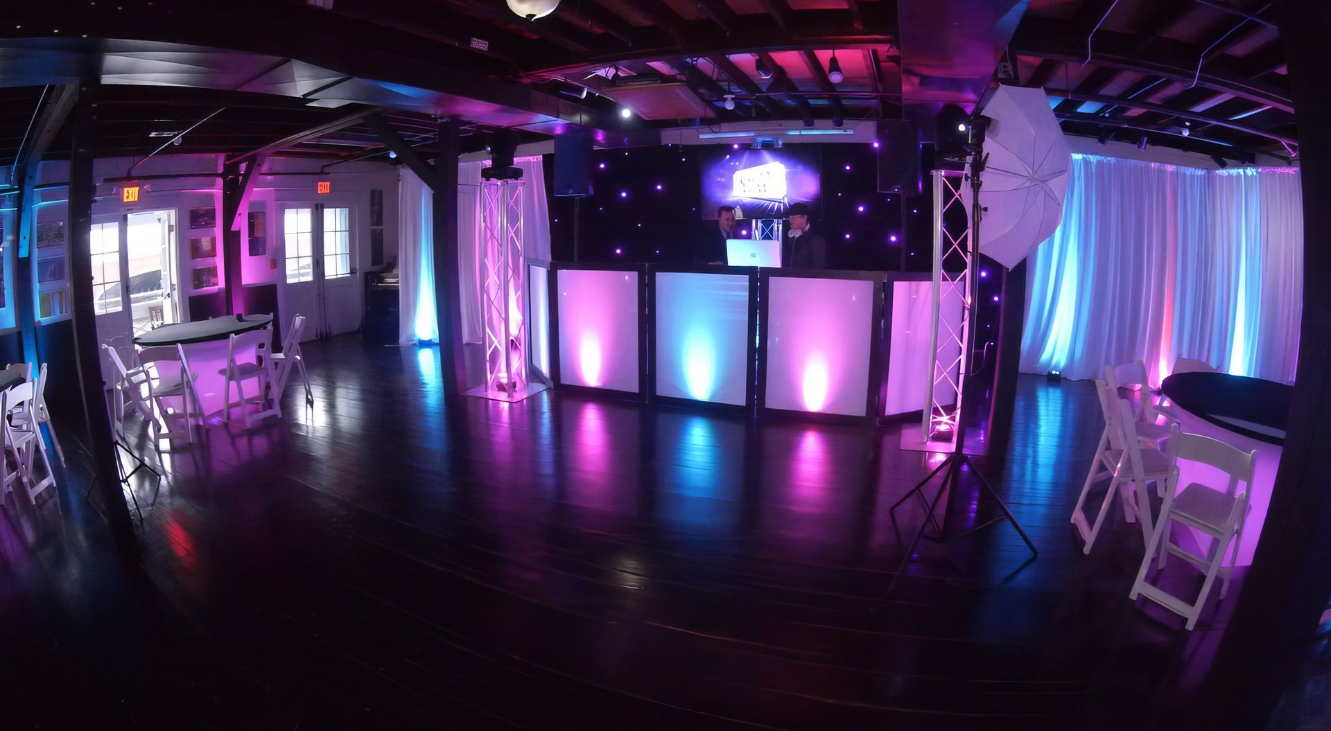 A bride and groom are dancing in front of a crowd of people at their wedding reception.