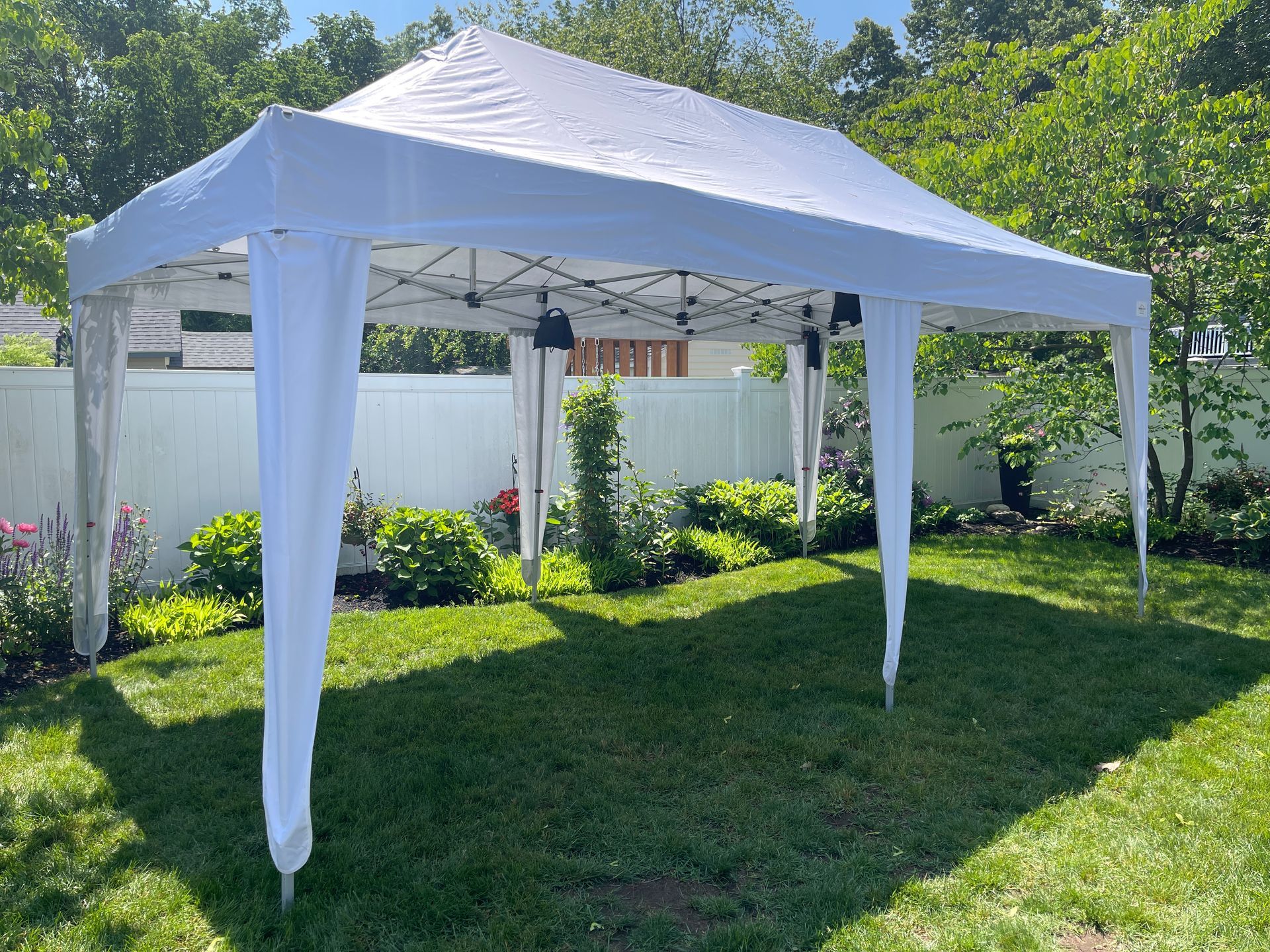 A white tent is sitting on top of a lush green lawn.