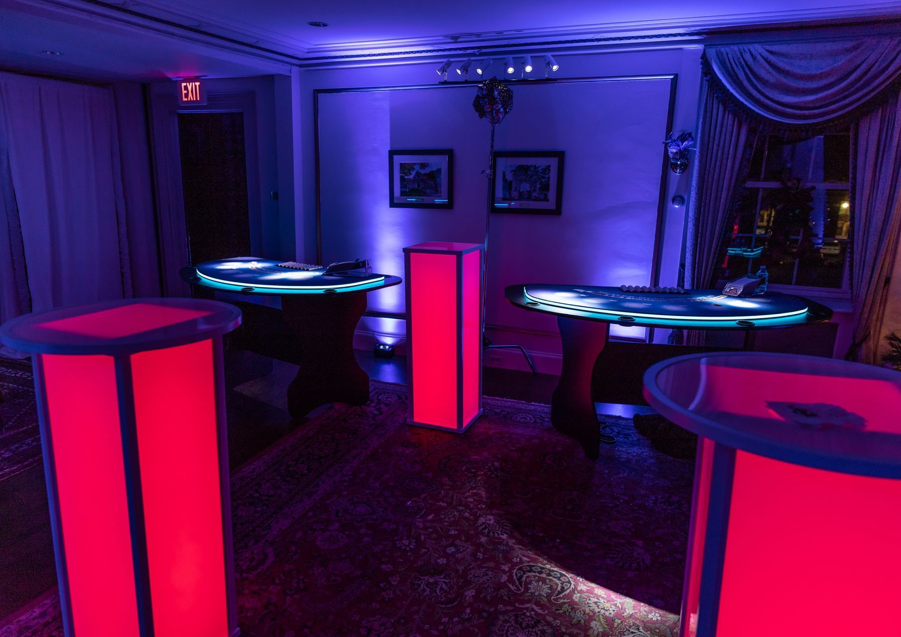 A room with a lot of tables and purple lights