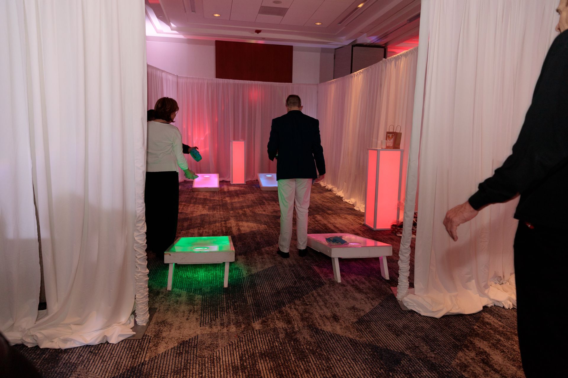 A dj is playing music at a party in a large room.