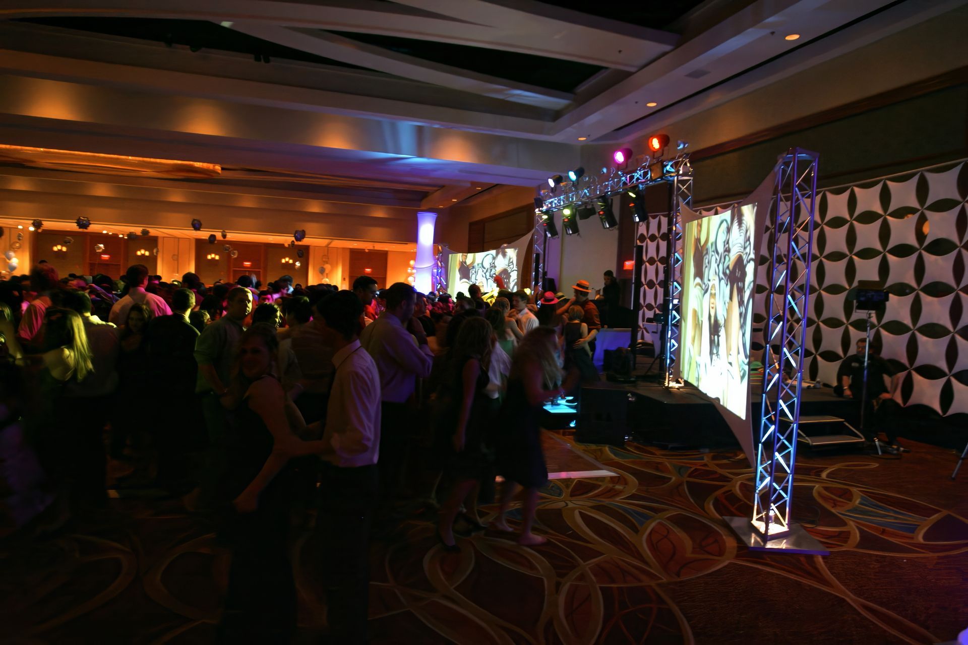 A bride and groom are dancing in front of a crowd of people at their wedding reception.