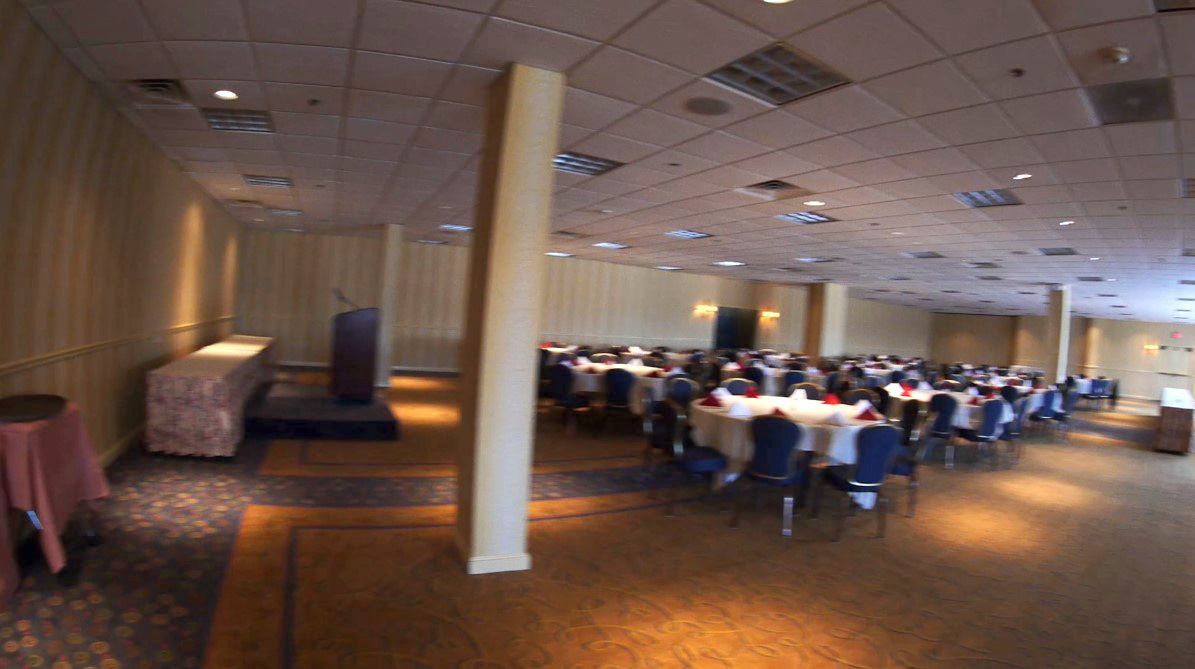 A large room with tables and chairs and a podium