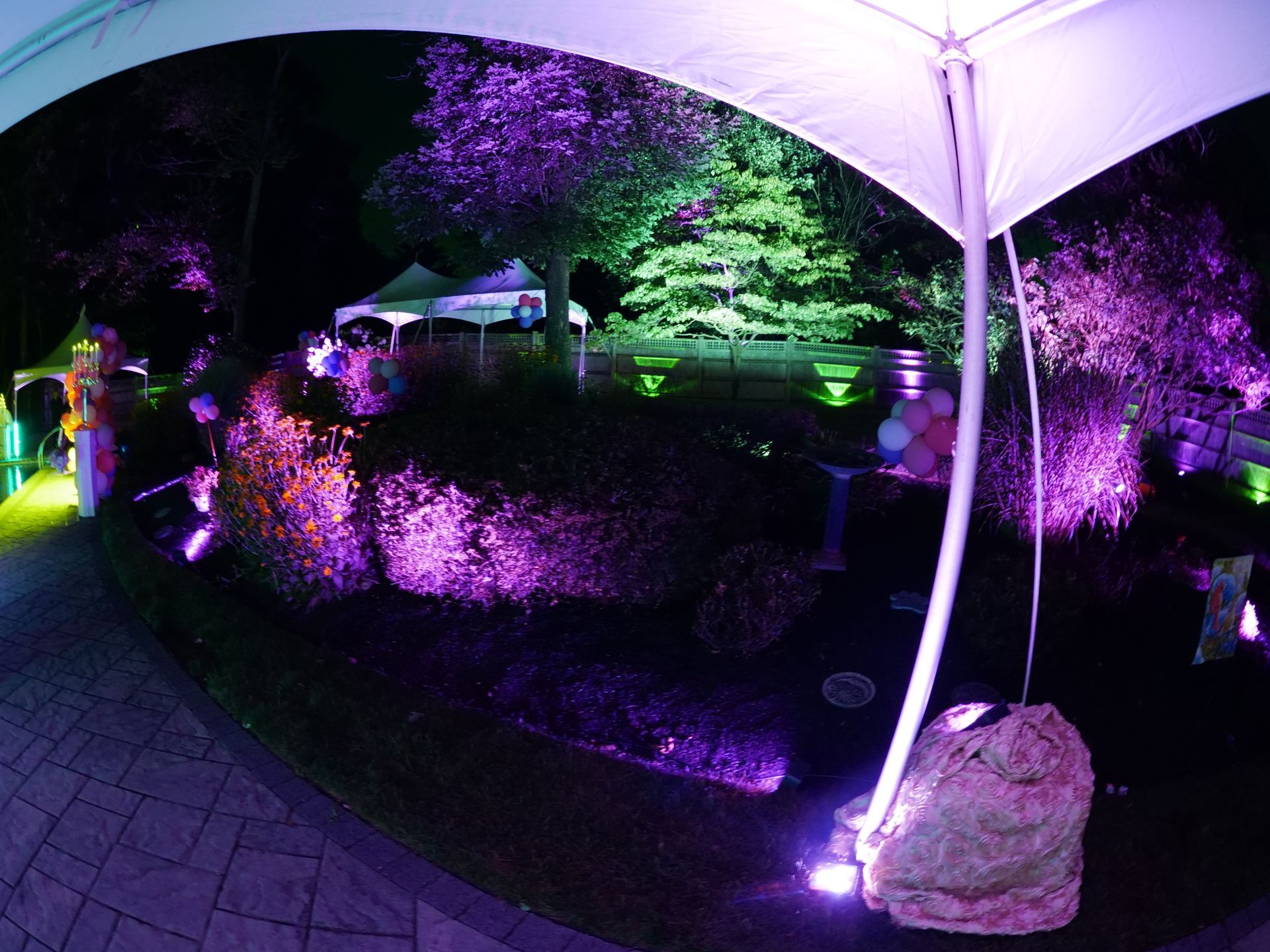 A bride and groom are dancing in front of a crowd of people at their wedding reception.