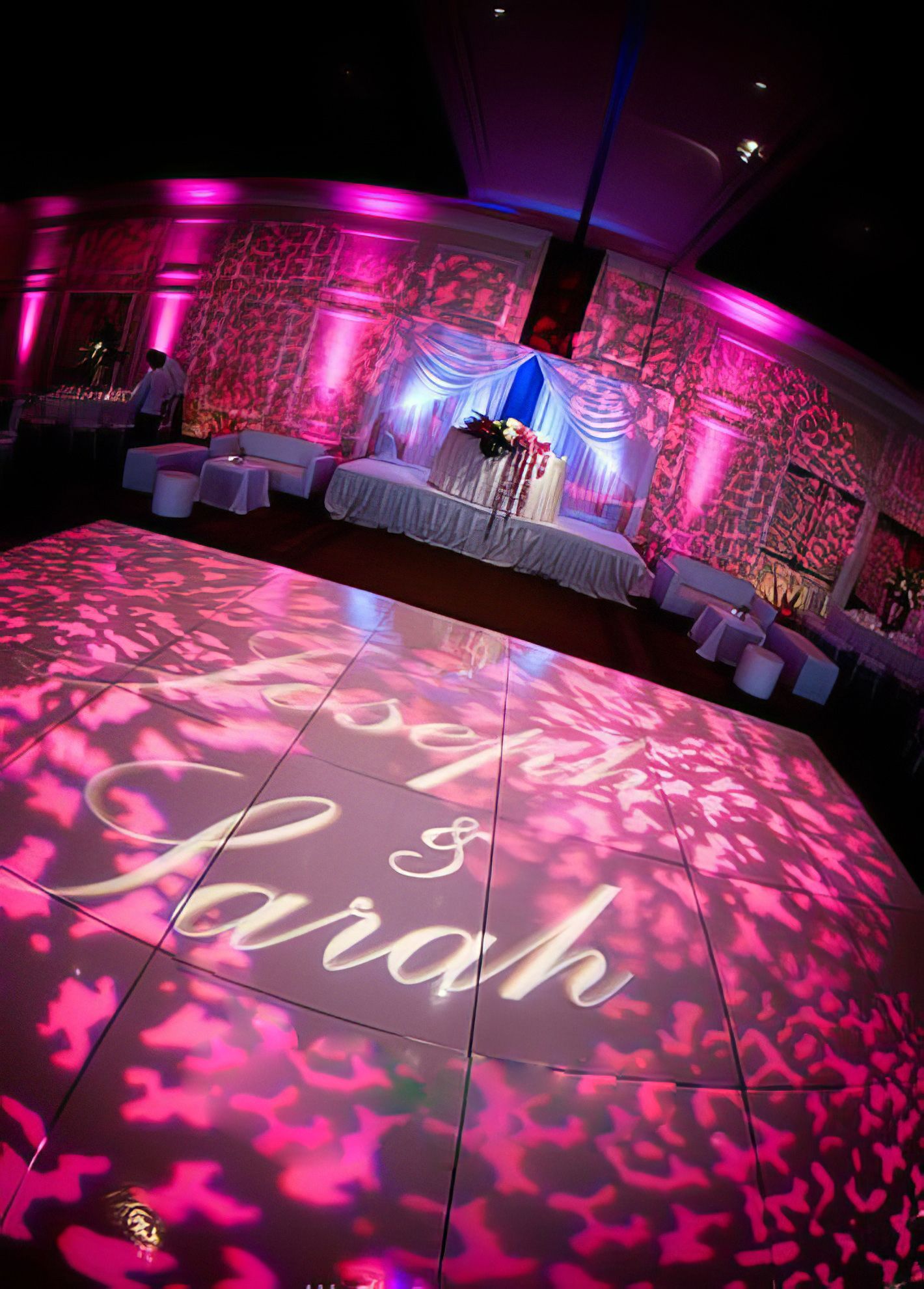A bride and groom are dancing on a dance floor in front of a crowd.