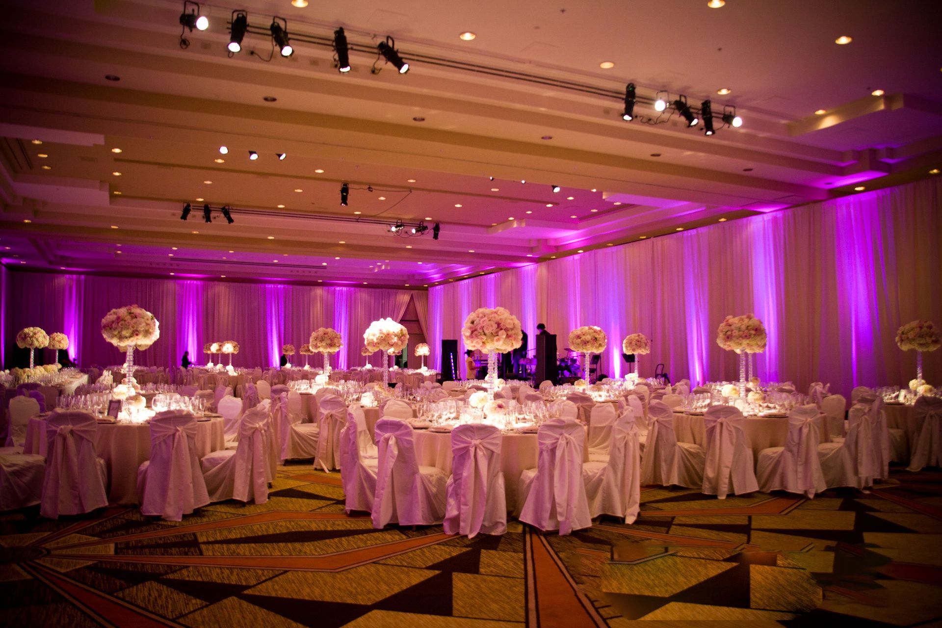 A large room with tables and chairs set up for a wedding reception.