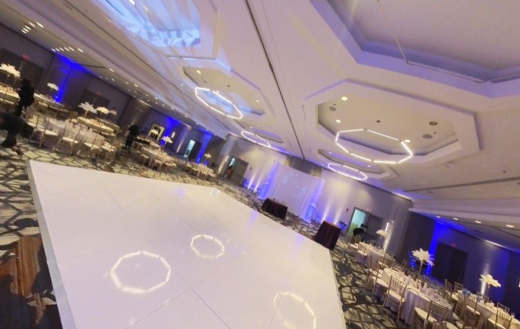 Harvard Boat Club room with Lit Tables, uplighting, Pipe and Drape chairs and a dj booth with Fiber Optic Backdrop and LED 65