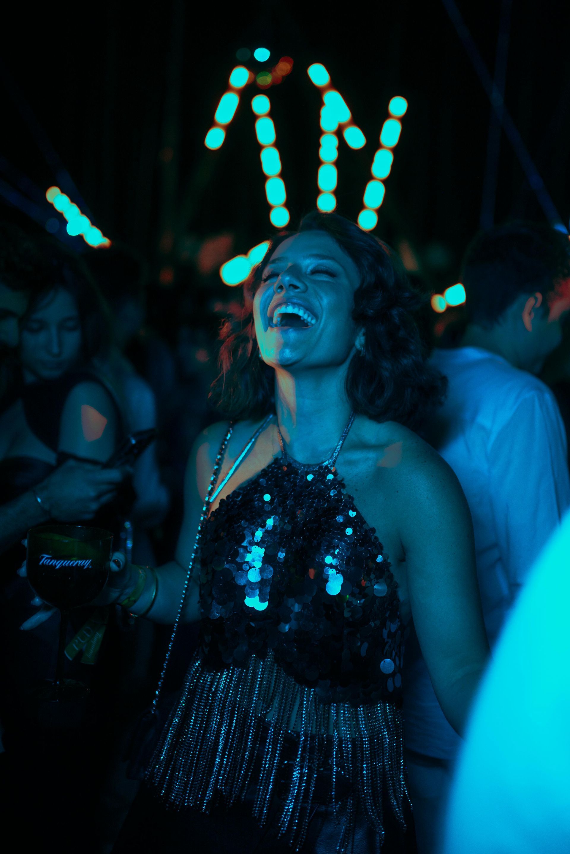 A dj is playing music at a party in a large room.