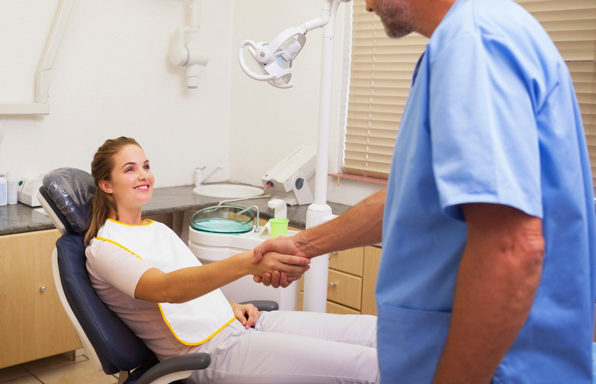 woman and dentist shaking hands