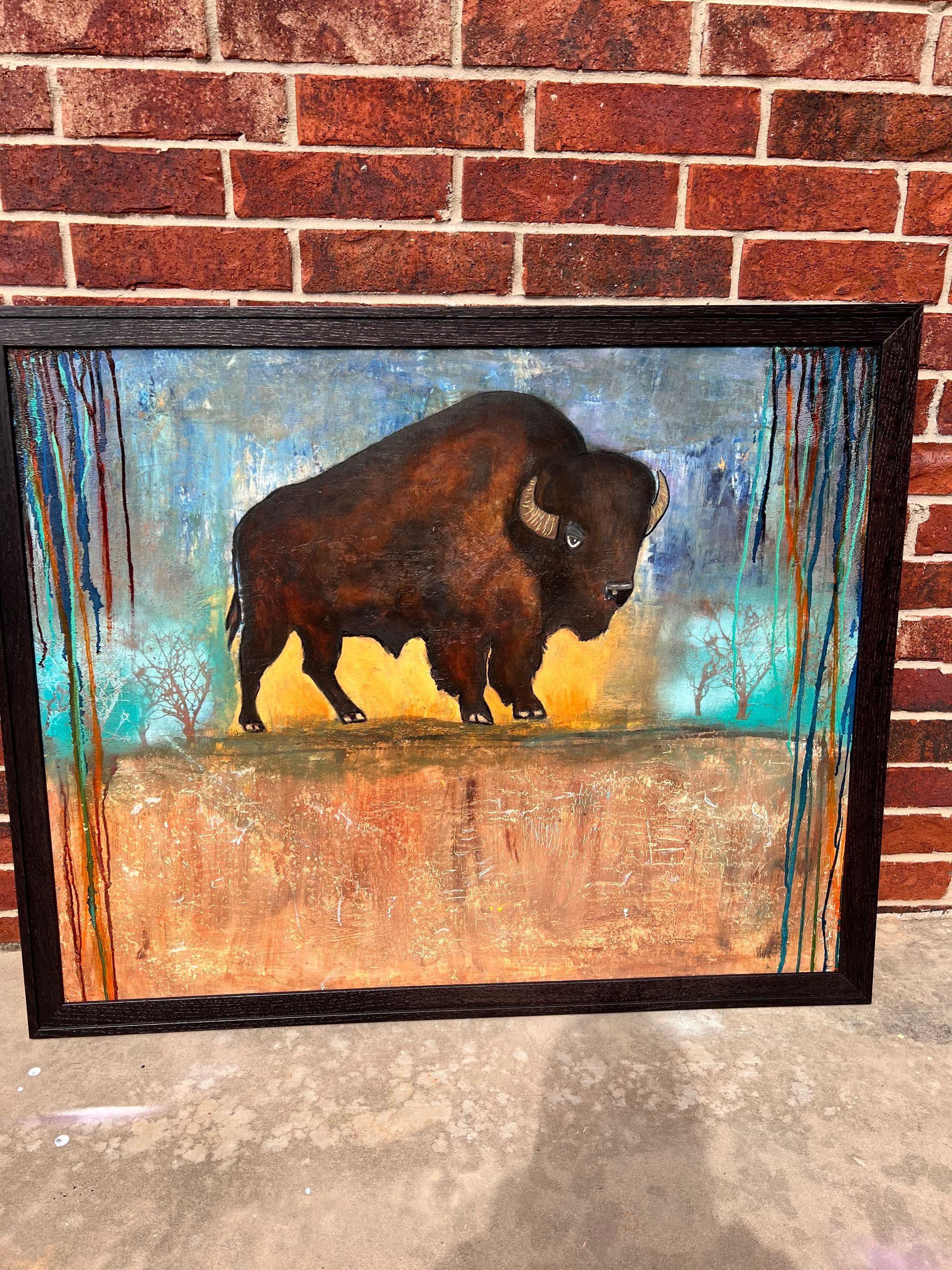 Painting of a bison standing on a brown ledge, against an abstract blue and orange background, in a black frame.