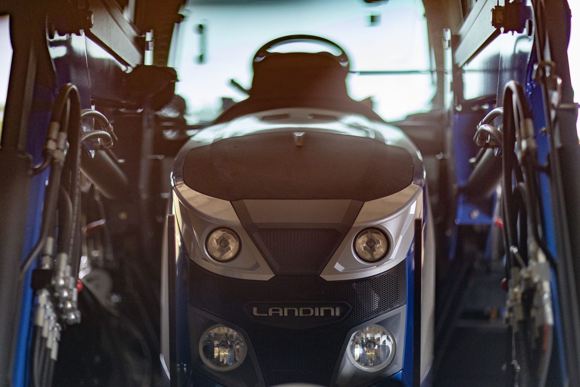 Front view of a blue and black Landini tractor, with headlights and grill visible.