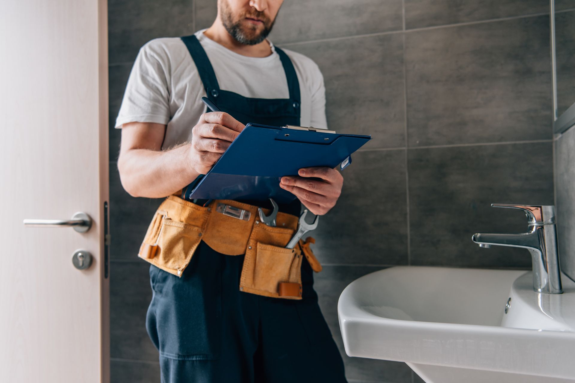 Plumber filling out form in bathroom