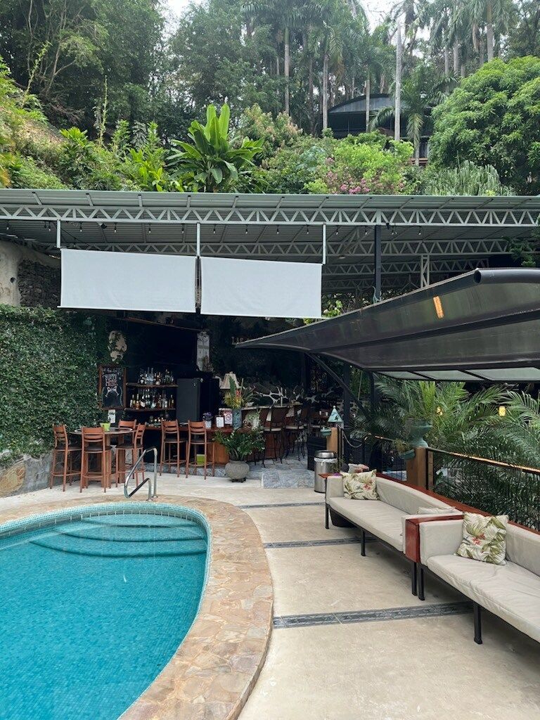 There is a large swimming pool in the middle of a lush green forest.