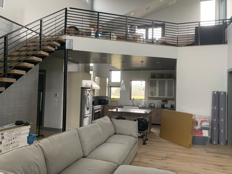 A living room with a couch and stairs leading to the second floor.