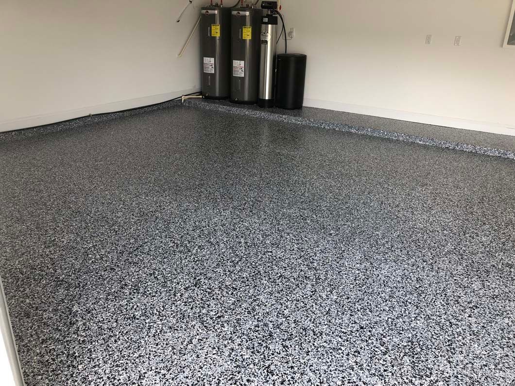 A garage with a gray floor and a white wall.