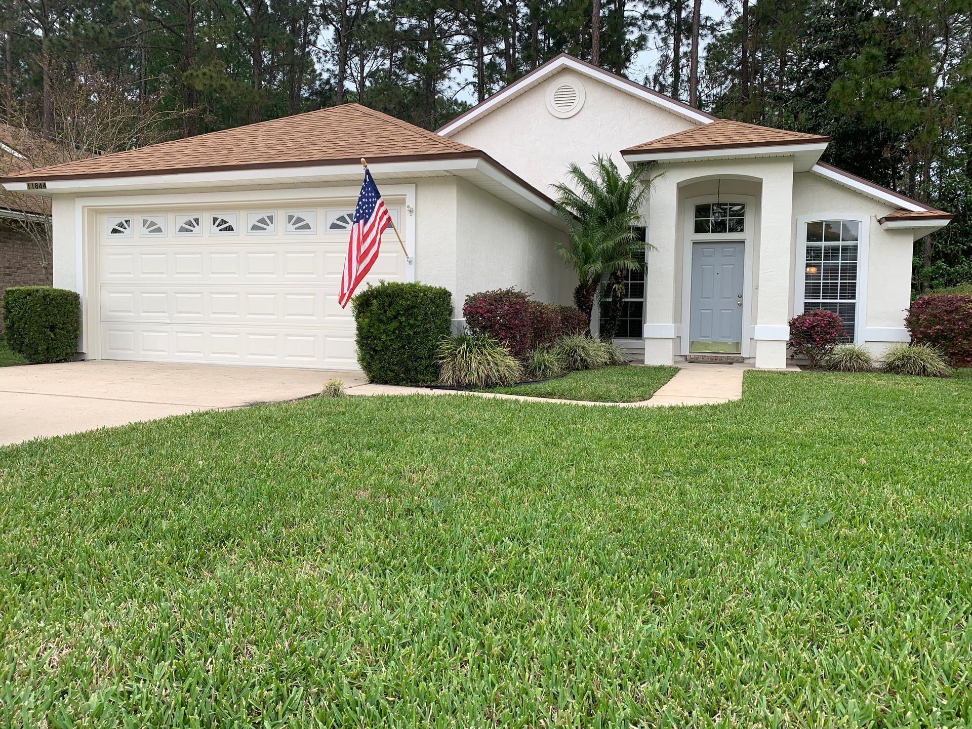 A white house with an american flag in front of it.