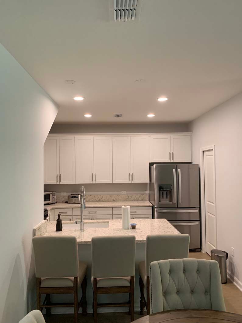 A kitchen with a table and chairs and a refrigerator.