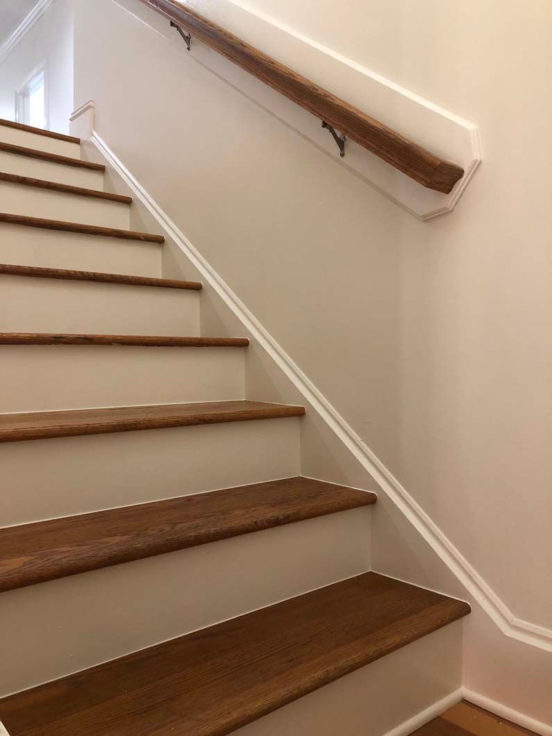 A staircase with wooden steps and a white railing