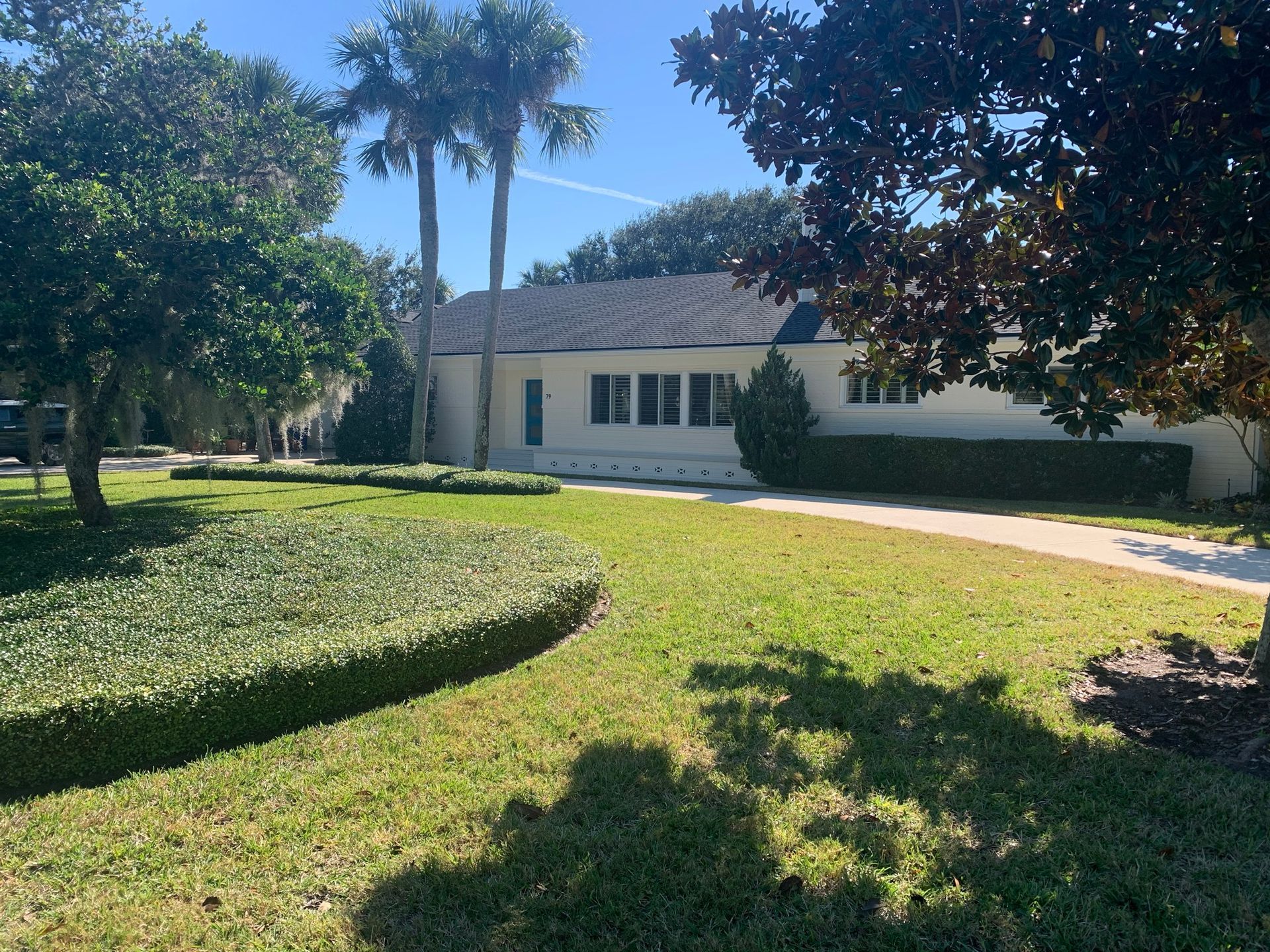 A house with a lot of grass and trees in front of it