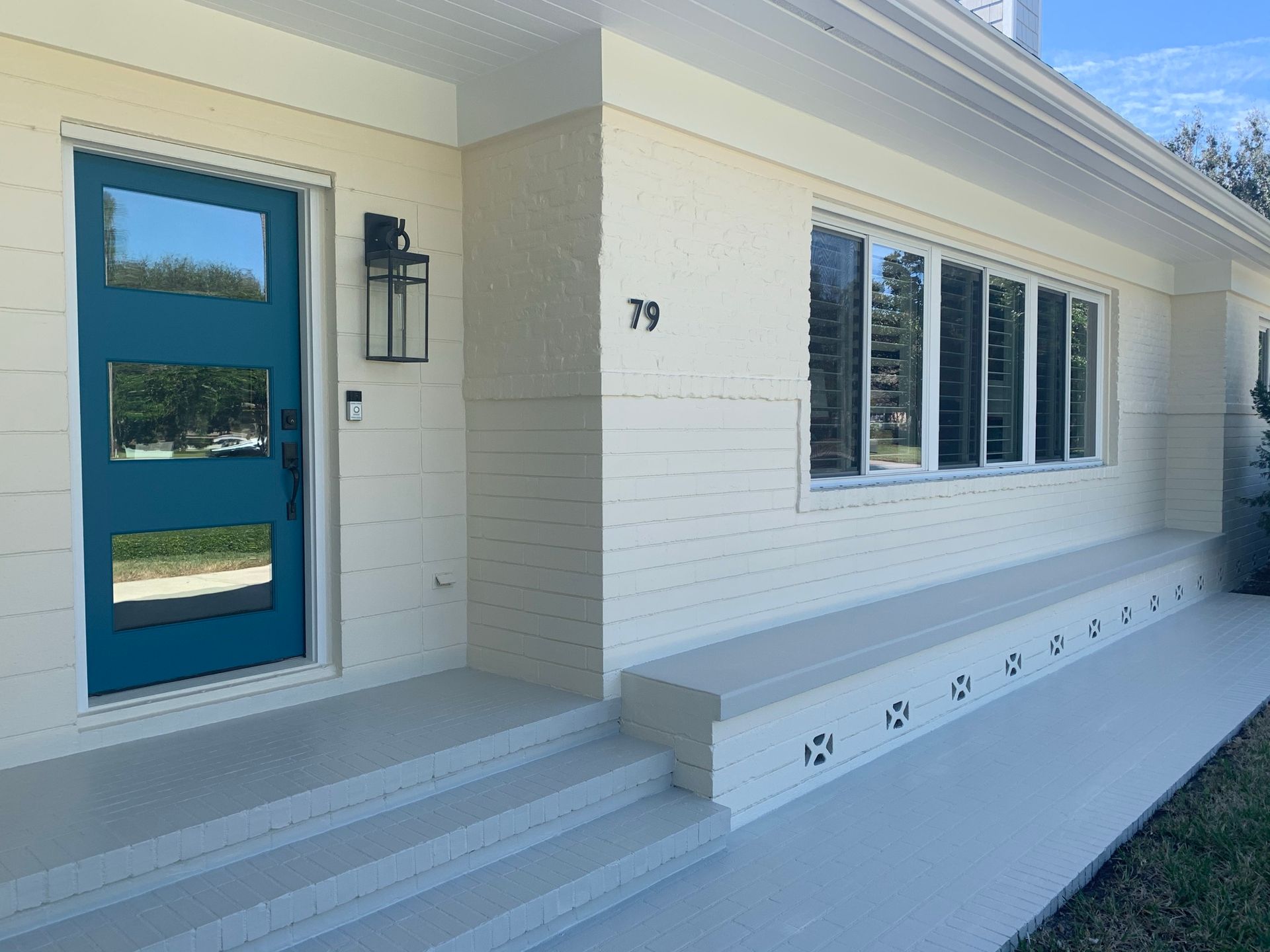 A white house with a blue door and windows