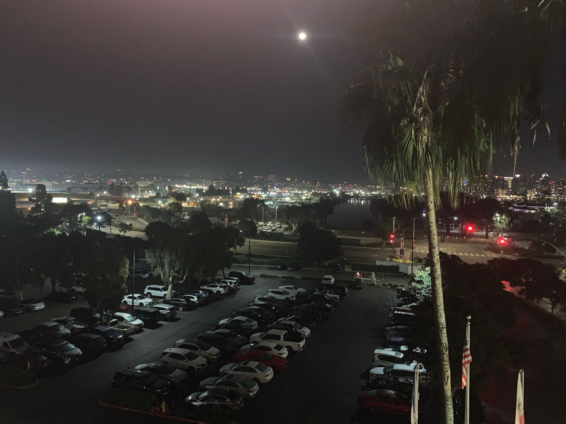 A parking lot with a city in the background at night