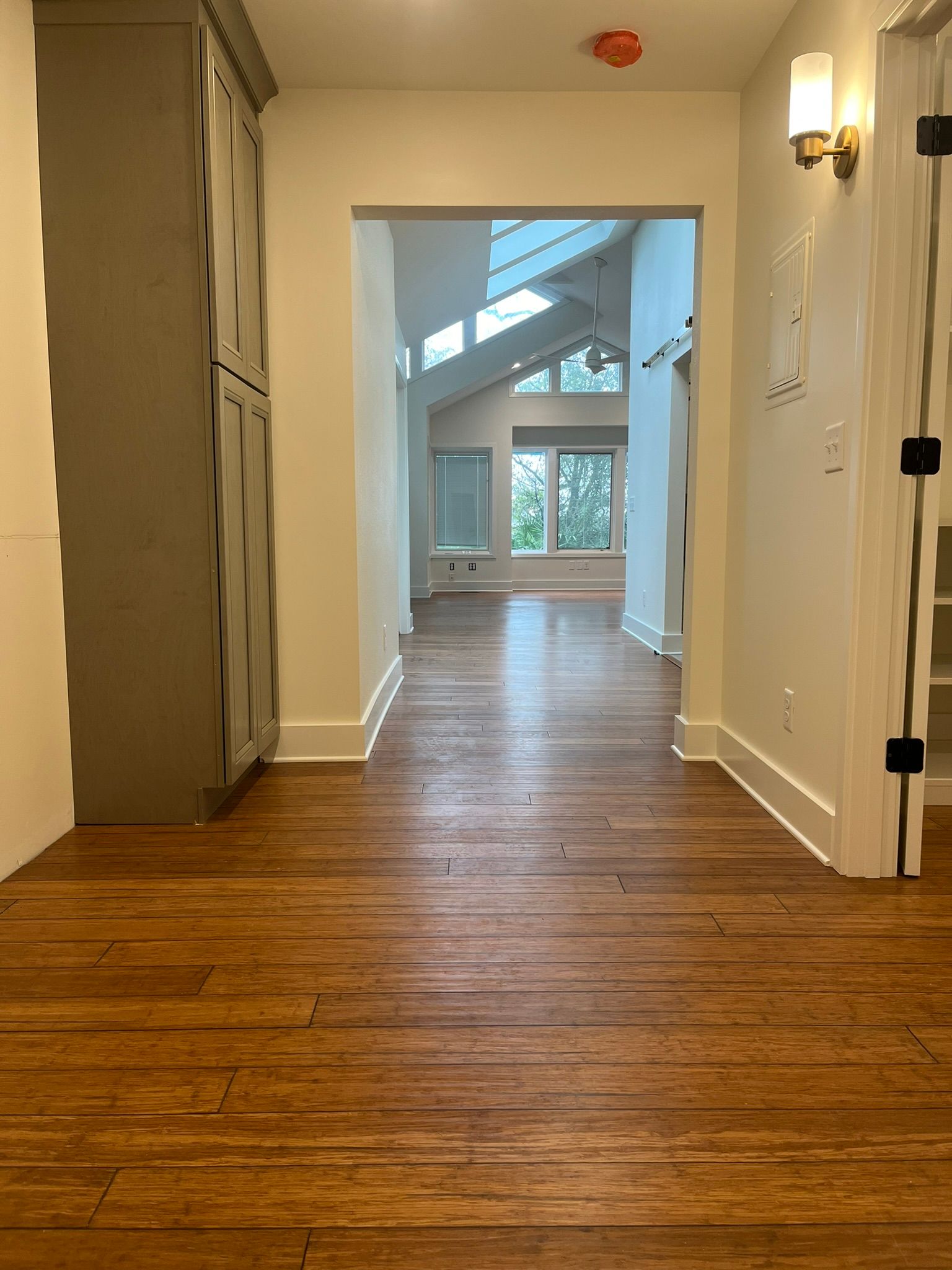 A hallway in a house with hardwood floors and white walls.