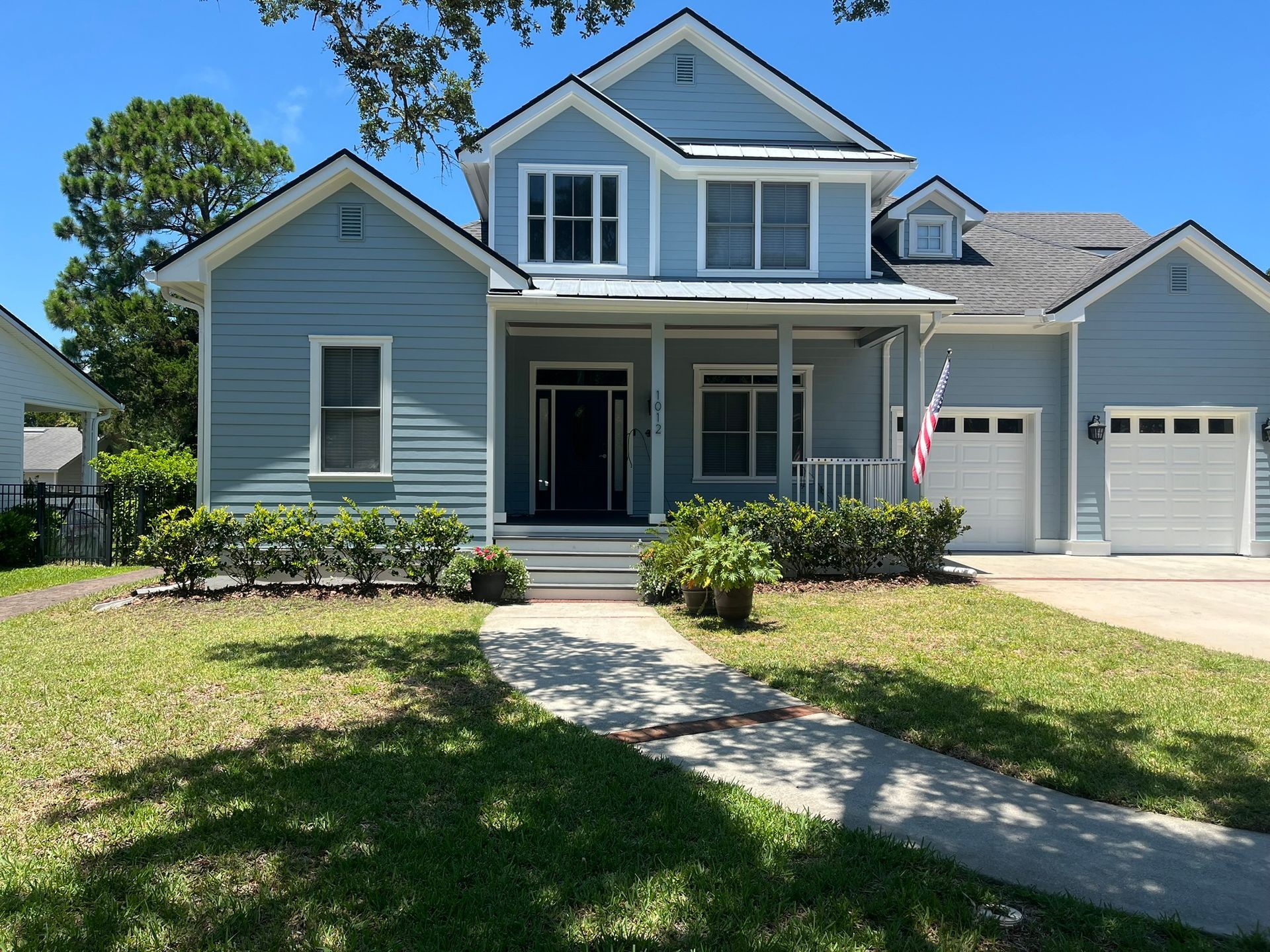 A large blue house with a white garage door