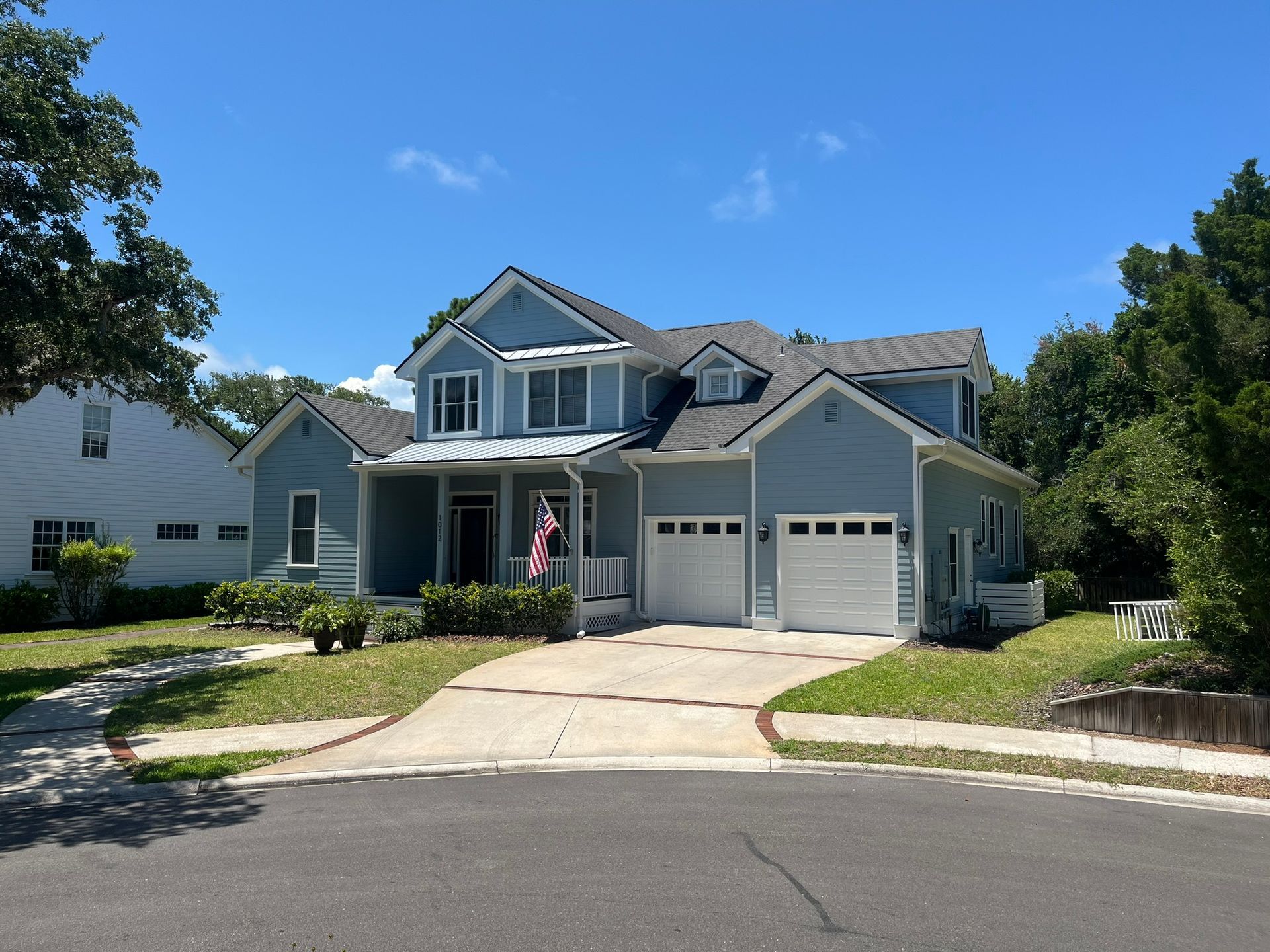 A large blue house with a white garage door