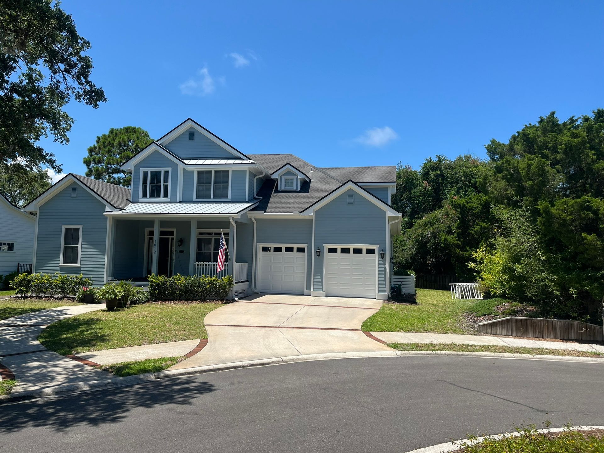 A large blue house with a white garage door