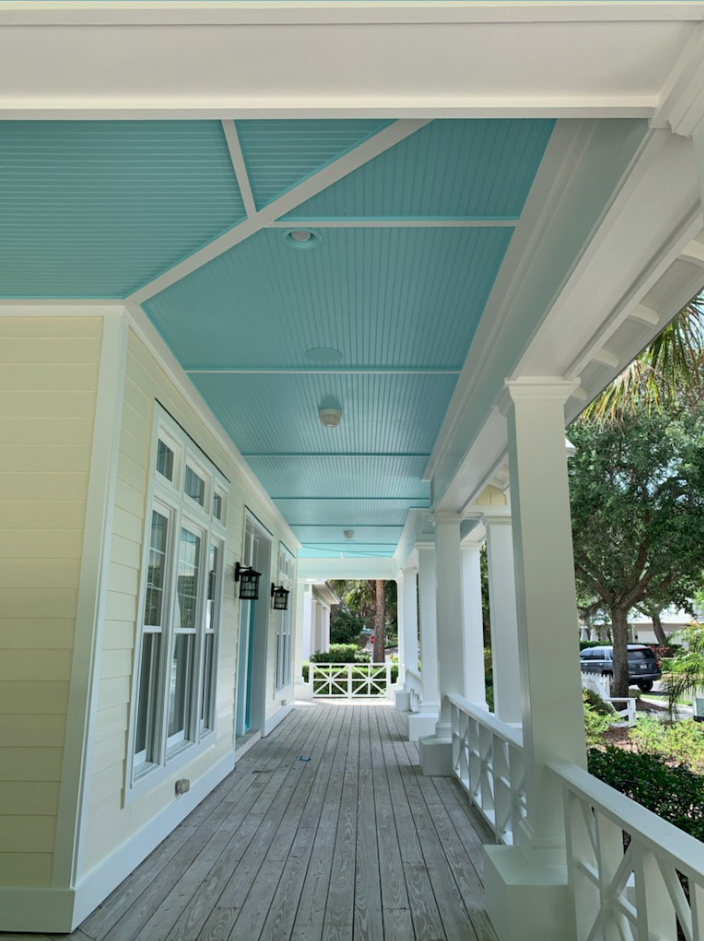 A porch with a blue ceiling and white trim