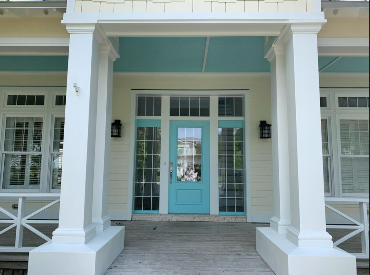 A white house with a blue door and white pillars