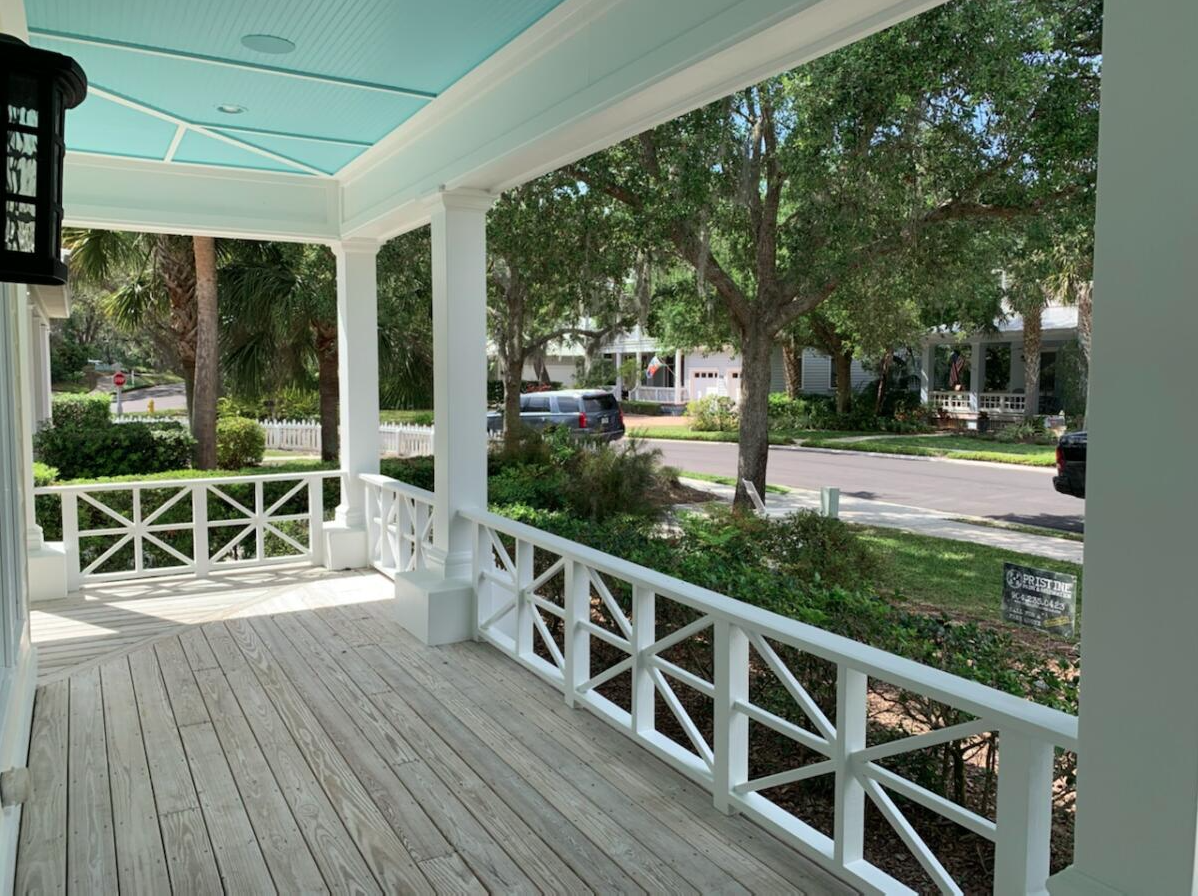 A porch with a blue roof and white railing