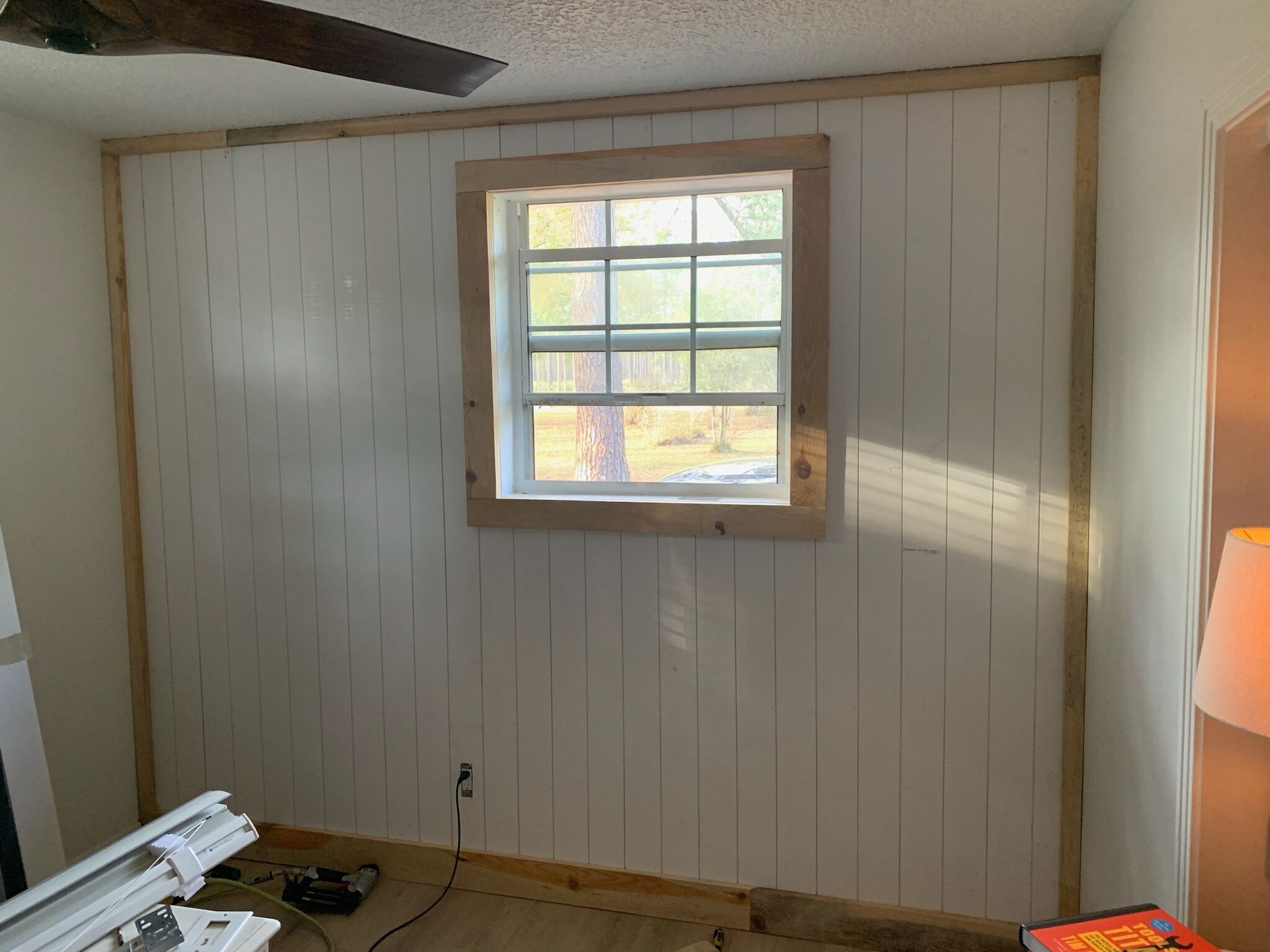 A room with a window and a ceiling fan.
