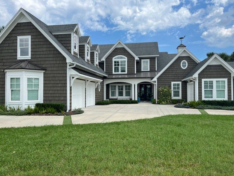 A large house with a lot of windows and a driveway