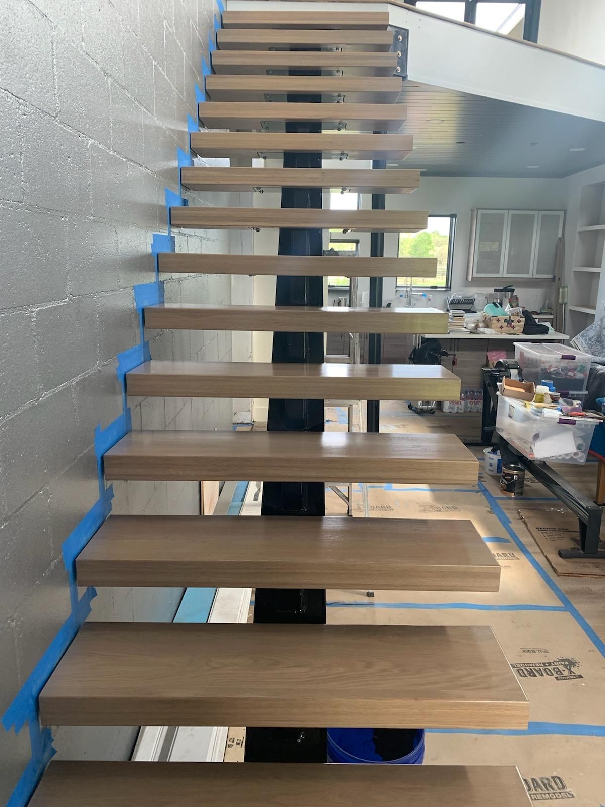 A wooden staircase with blue tape on the steps
