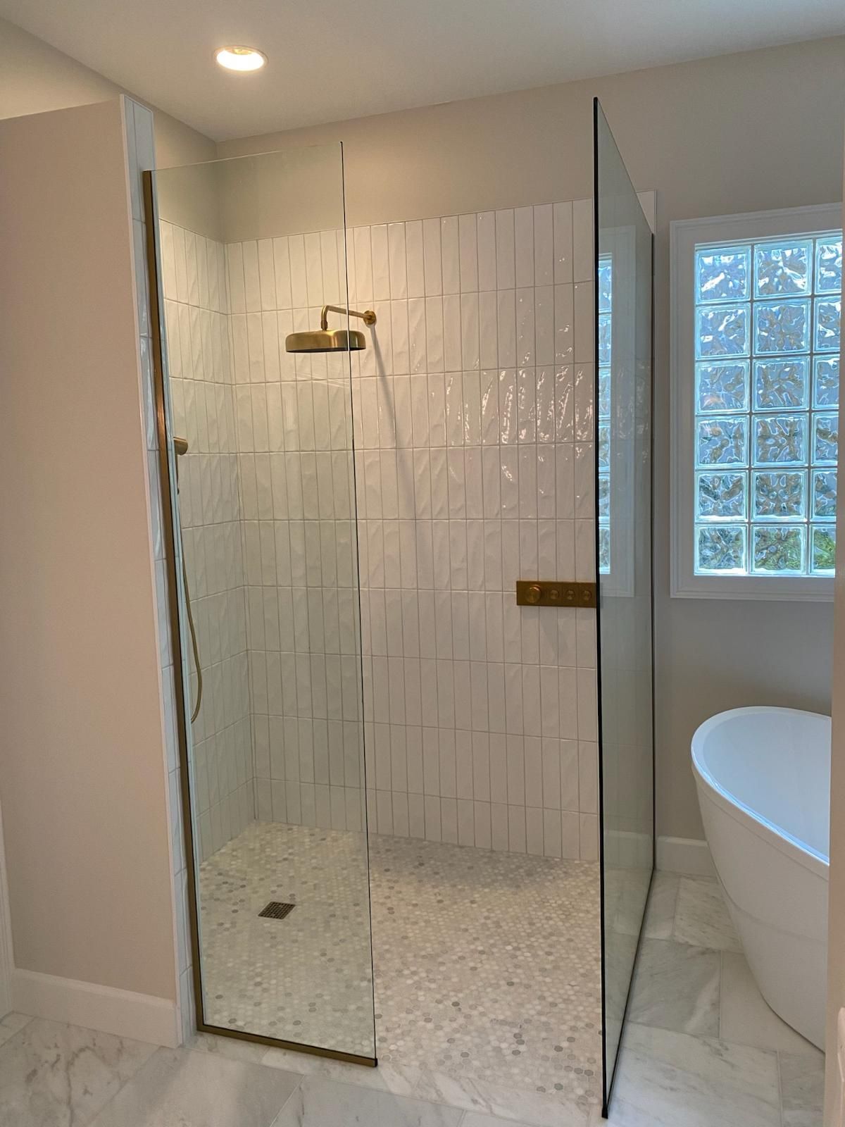 A bathroom with a walk in shower and a bathtub.