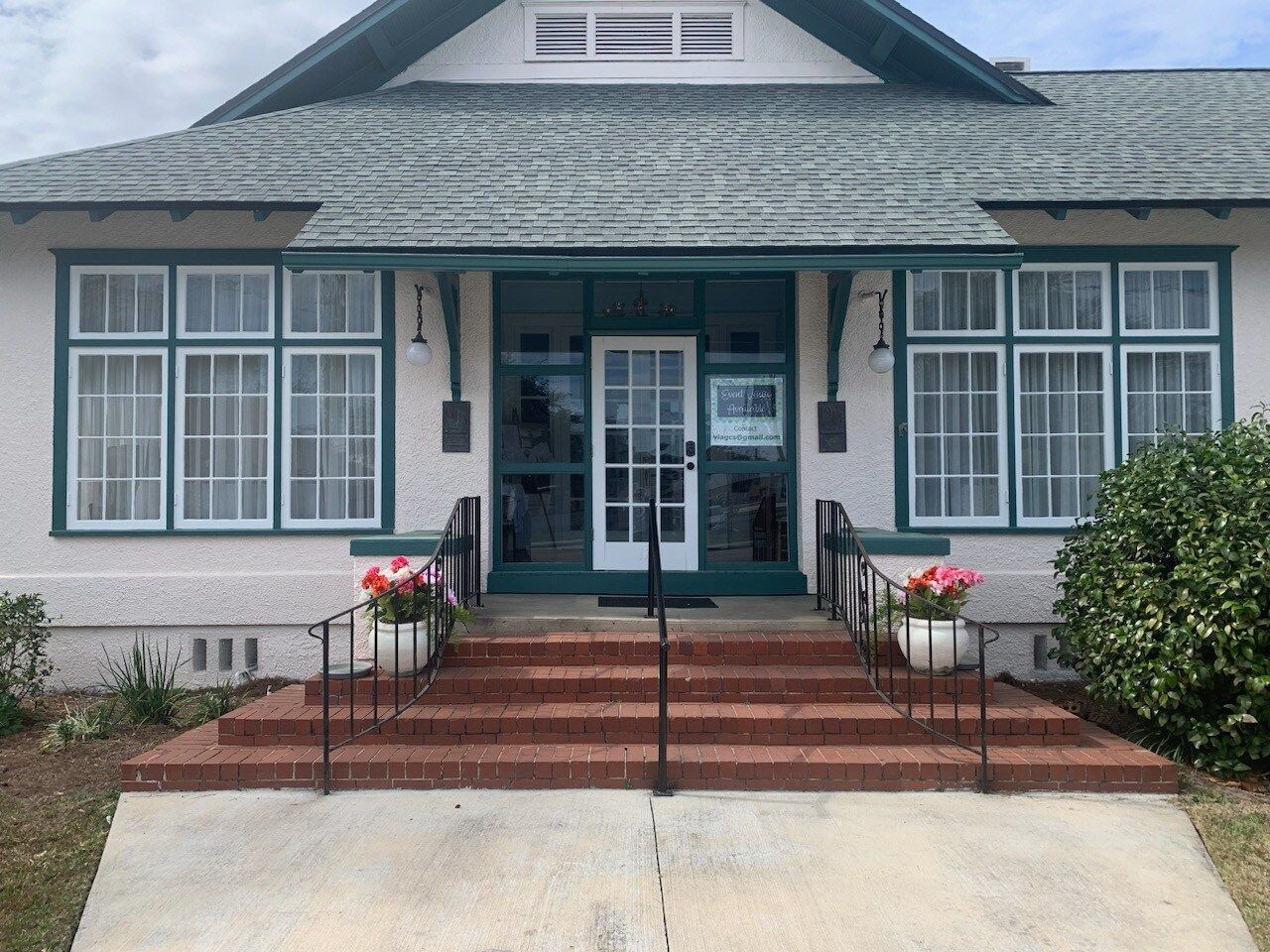 The front of a house with a green door and stairs
