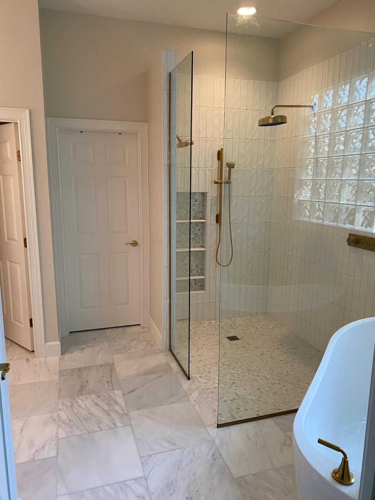 A bathroom with a walk in shower and a bathtub.