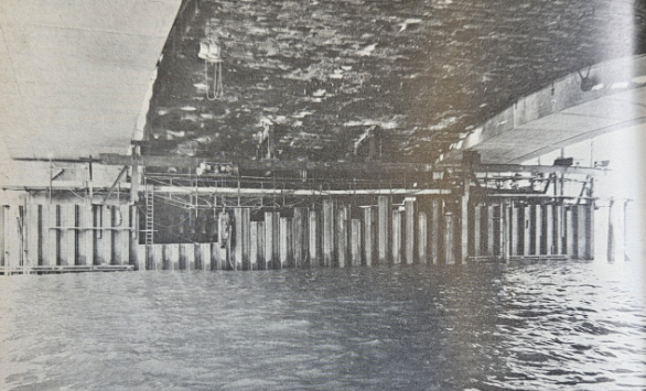 A view underneath the building of the modern bridge showing the new sections on either side of the old one.